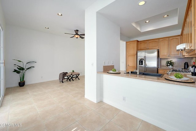 kitchen with tasteful backsplash, stainless steel fridge with ice dispenser, light tile patterned floors, a tray ceiling, and range hood