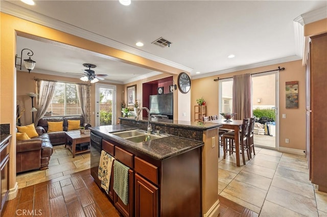 kitchen with sink, crown molding, a center island with sink, dark stone countertops, and black dishwasher