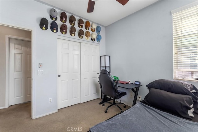 carpeted bedroom with ceiling fan and a closet