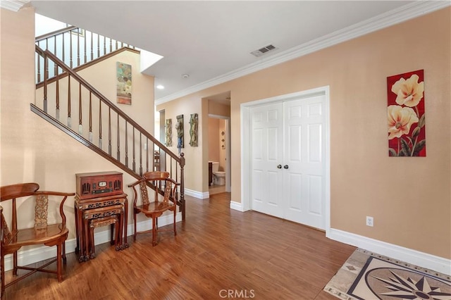 entrance foyer with crown molding and hardwood / wood-style floors