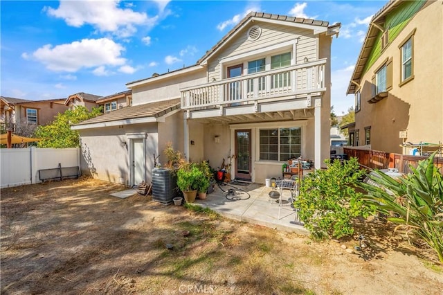 rear view of property with a patio area and a balcony