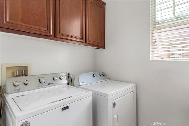 washroom with cabinets and washing machine and dryer