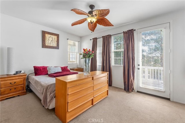 bedroom featuring multiple windows, light carpet, access to exterior, and ceiling fan