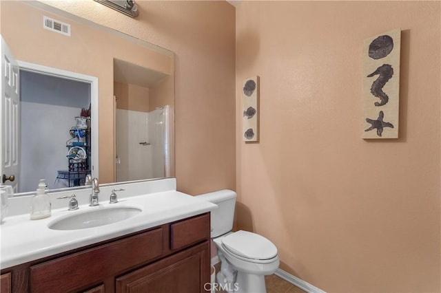 bathroom featuring vanity, a shower, and toilet