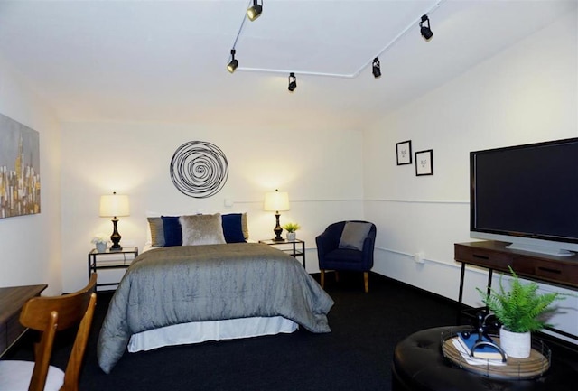 carpeted bedroom featuring track lighting