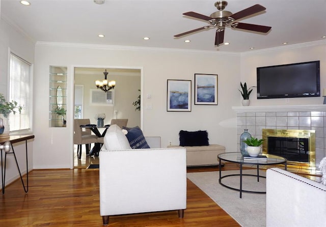 living room featuring dark hardwood / wood-style flooring, a tiled fireplace, and ornamental molding