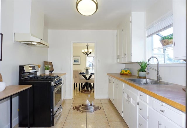 kitchen with white cabinetry, sink, custom exhaust hood, light tile patterned floors, and stainless steel gas range