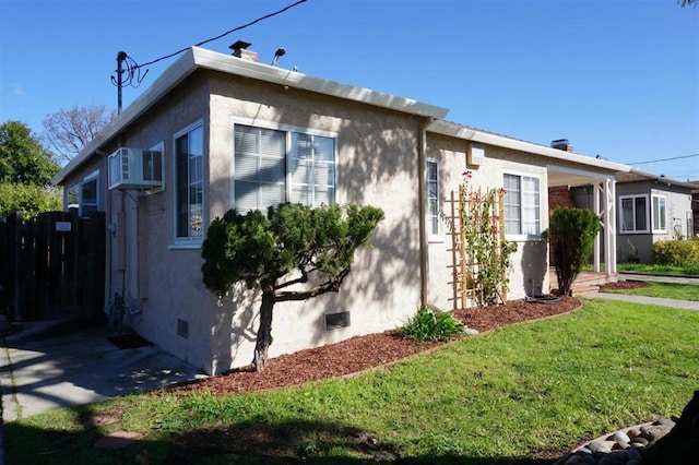 view of side of home featuring a yard and a wall mounted AC