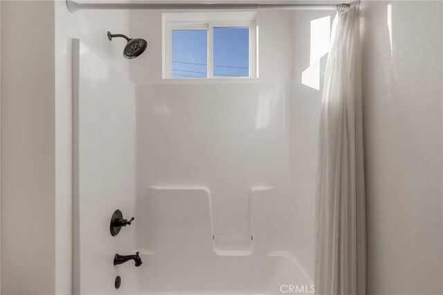 bathroom with shower / bath combo with shower curtain