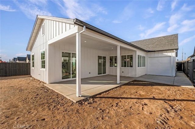 back of house with a garage and a patio