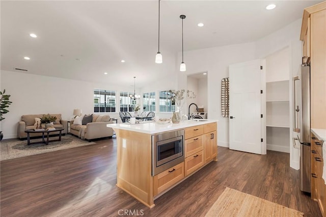 kitchen with dark wood-type flooring, sink, light brown cabinets, appliances with stainless steel finishes, and an island with sink