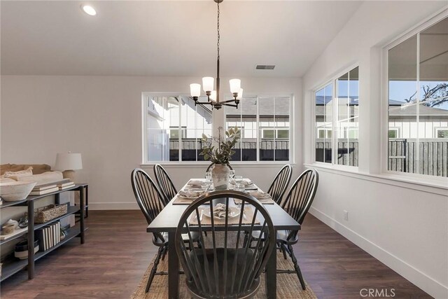 dining space featuring dark hardwood / wood-style floors and a notable chandelier