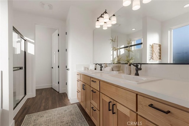 bathroom featuring hardwood / wood-style flooring, vanity, and a shower with shower door