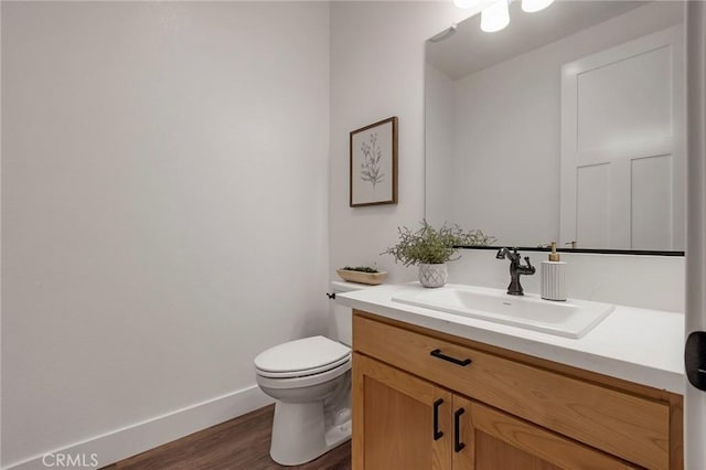 bathroom with vanity, hardwood / wood-style floors, and toilet