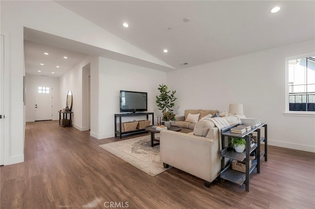 living room with dark wood-type flooring, plenty of natural light, and vaulted ceiling