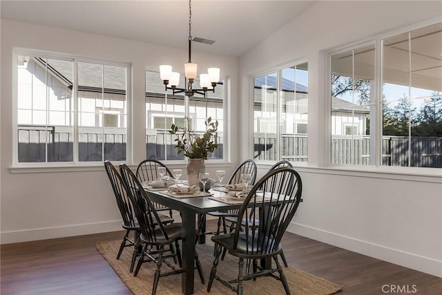 dining room featuring vaulted ceiling, dark wood-type flooring, and a chandelier