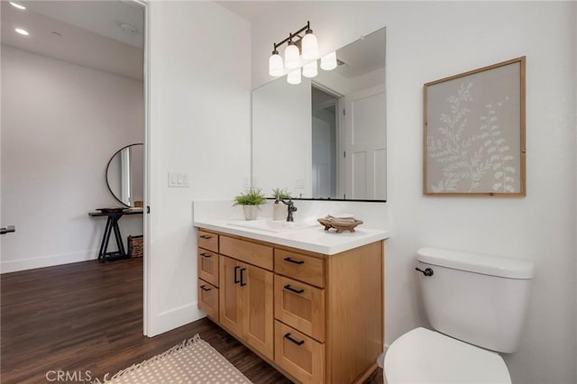 bathroom featuring vanity, toilet, and hardwood / wood-style floors