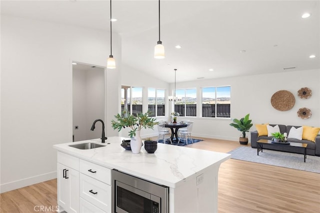 9 Harkness Ct, Chico, CA 95973 - kitchen with a sink, stainless steel microwave, open floor plan, white cabinetry, and lofted ceiling