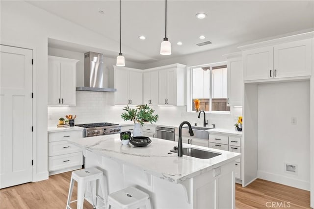 9 Harkness Ct, Chico, CA 95973 - kitchen with wall chimney range hood, a sink, white cabinetry, light wood-style flooring, and backsplash