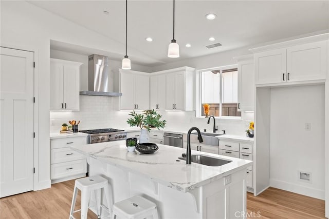 9 Harkness Ct, Chico, CA 95973 - kitchen featuring wall chimney range hood, white cabinets, light wood-style flooring, decorative backsplash, and recessed lighting