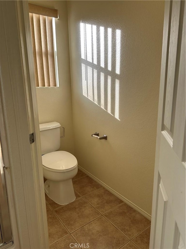 bathroom with tile patterned flooring and toilet