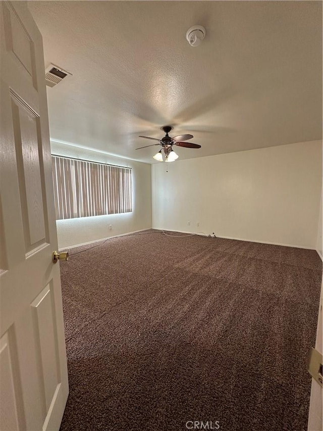 unfurnished room with ceiling fan, a textured ceiling, and carpet