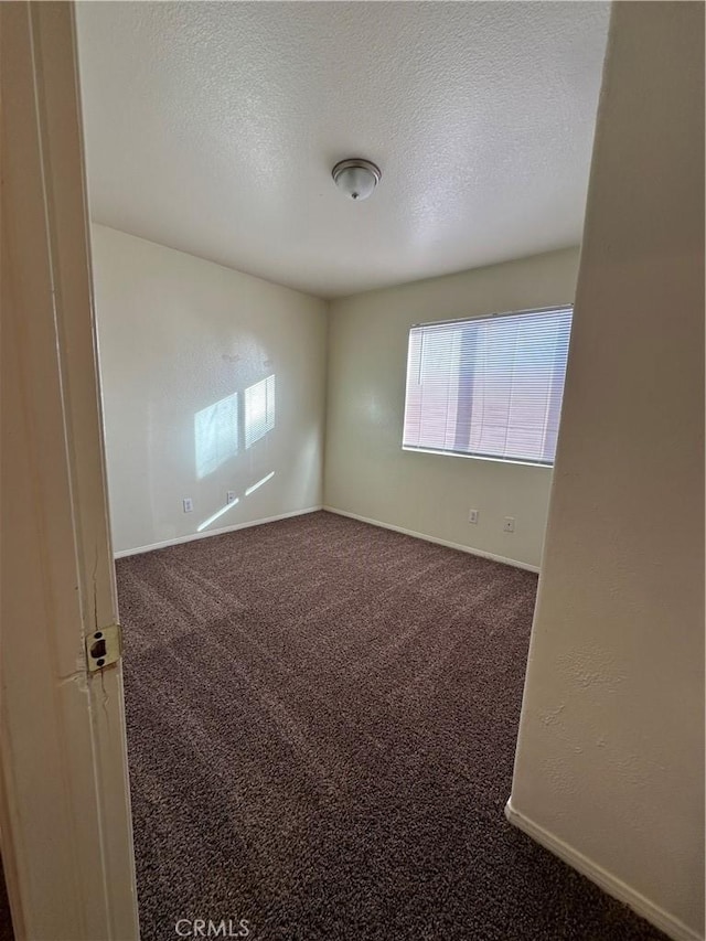 spare room featuring carpet and a textured ceiling