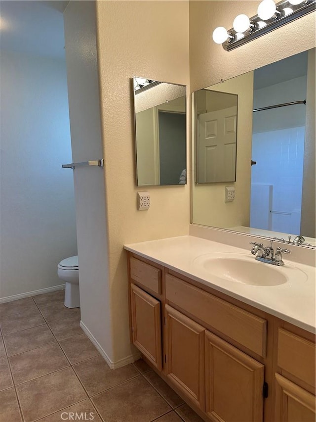 bathroom featuring tile patterned flooring, vanity, and toilet