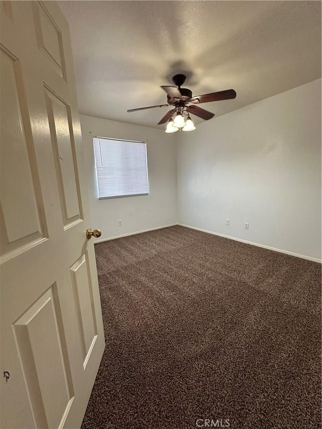 carpeted spare room featuring ceiling fan and a textured ceiling