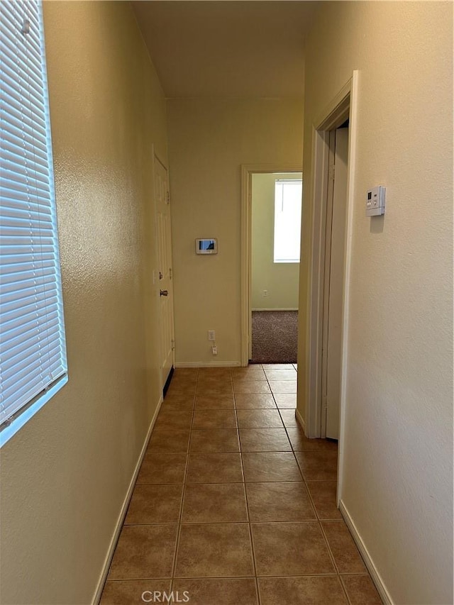 corridor featuring dark tile patterned flooring