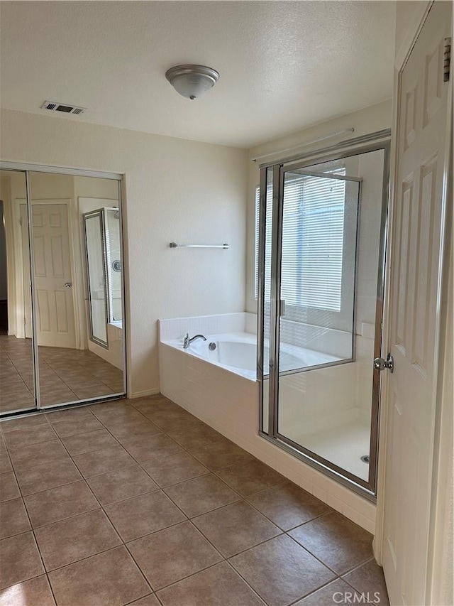 bathroom featuring tile patterned floors, independent shower and bath, and a textured ceiling