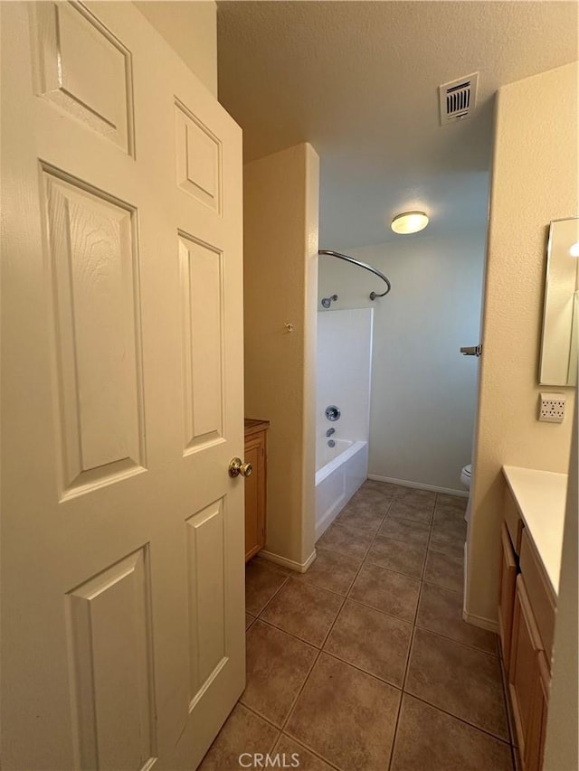 full bathroom with vanity, tub / shower combination, tile patterned floors, and toilet