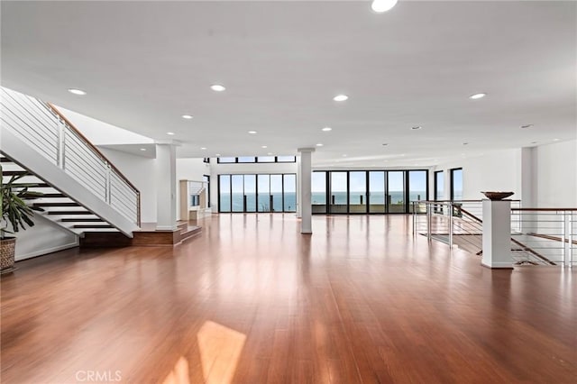 interior space with a water view, floor to ceiling windows, and hardwood / wood-style flooring