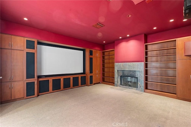 carpeted home theater room featuring a fireplace