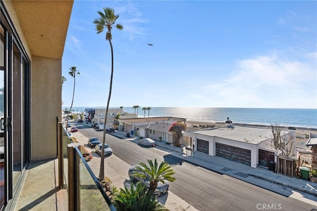 balcony featuring a beach view and a water view