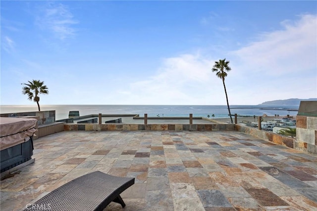 view of patio / terrace with a water and mountain view