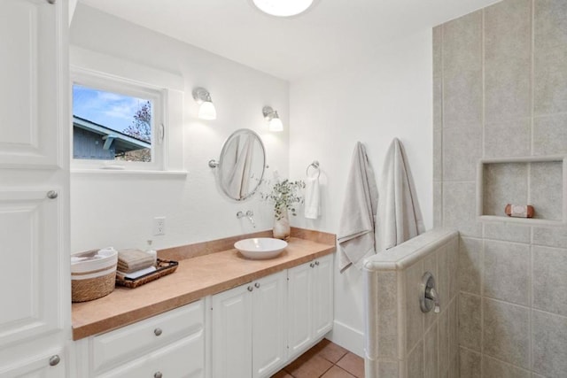 bathroom featuring vanity, tile patterned floors, and a tile shower