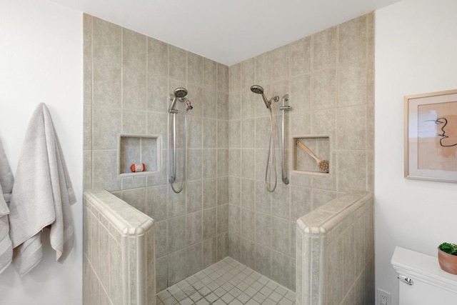 bathroom with a tile shower, radiator, and toilet