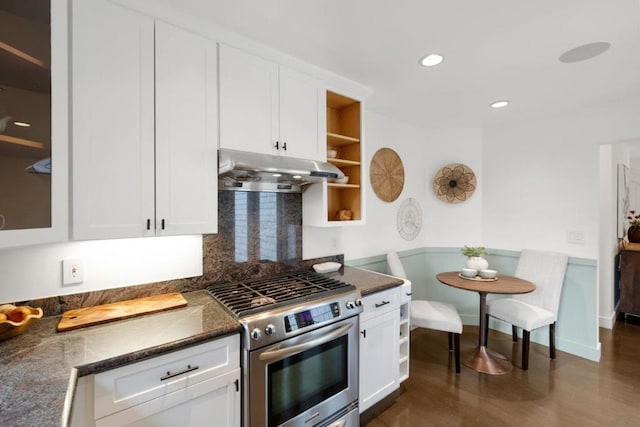 kitchen with tasteful backsplash, dark stone counters, gas stove, and white cabinets