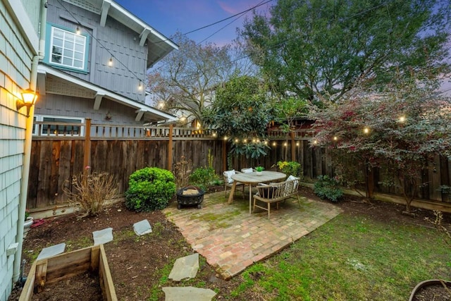 yard at dusk featuring a patio