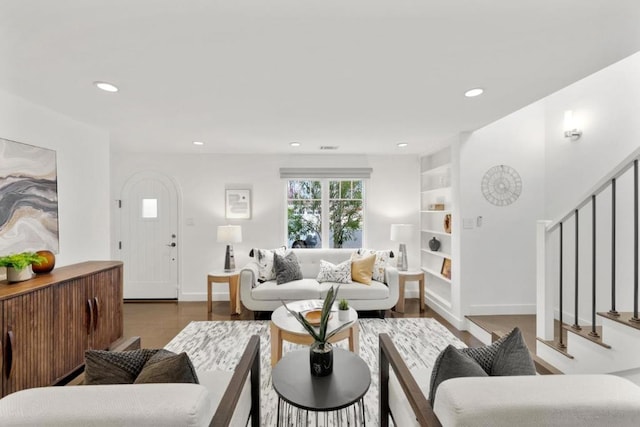 living room featuring built in features and light hardwood / wood-style flooring