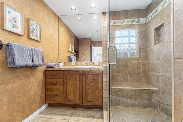 bathroom with tile patterned floors, vanity, and a shower with shower door