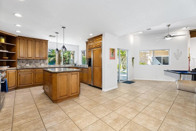 kitchen with tasteful backsplash, light tile patterned floors, paneled refrigerator, a kitchen island, and pendant lighting