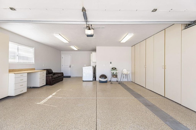 garage featuring fridge, a garage door opener, and washer / dryer