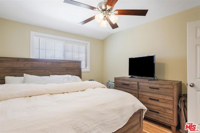 bedroom with lofted ceiling, ceiling fan, and light wood-type flooring