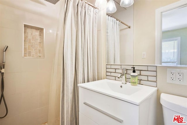 bathroom with tasteful backsplash, vanity, toilet, and a shower with curtain