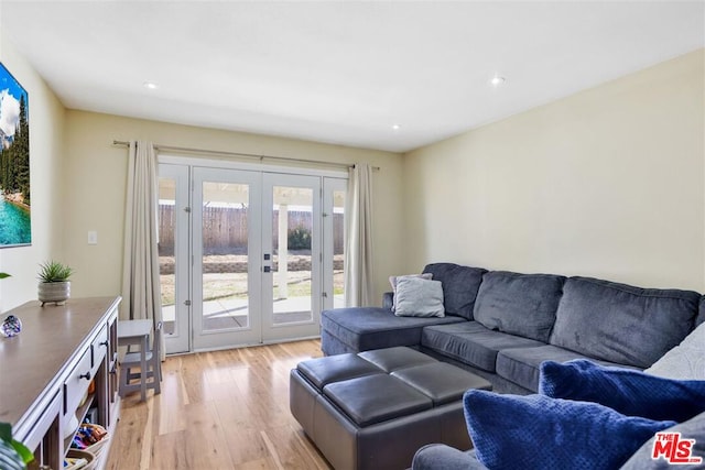 living room featuring french doors and light hardwood / wood-style flooring