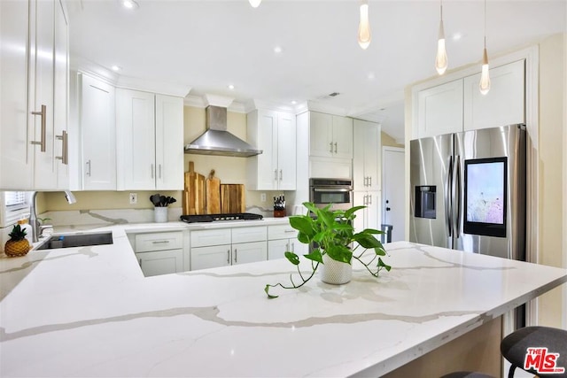 kitchen featuring wall chimney exhaust hood, sink, appliances with stainless steel finishes, a kitchen breakfast bar, and pendant lighting