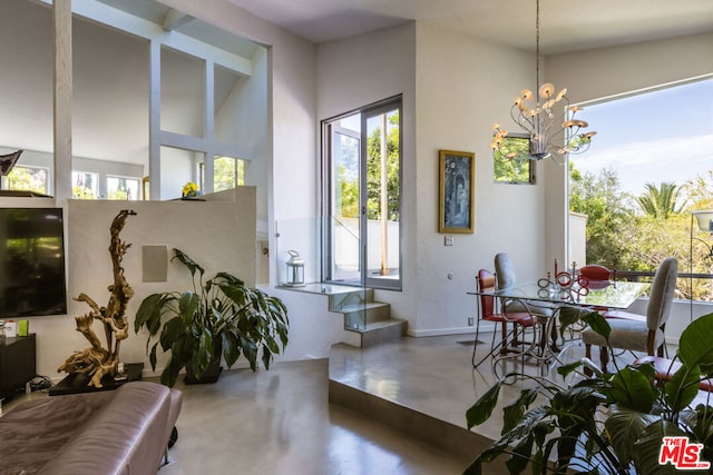 dining area with concrete floors and a chandelier