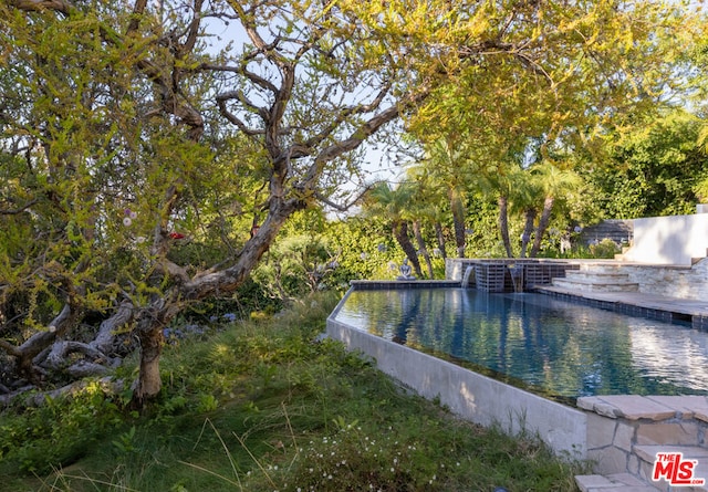 view of swimming pool featuring a water view